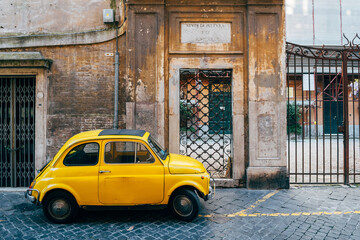 a classic fiat 500 vehicle is parked in roman street - obrazy, fototapety, plakaty