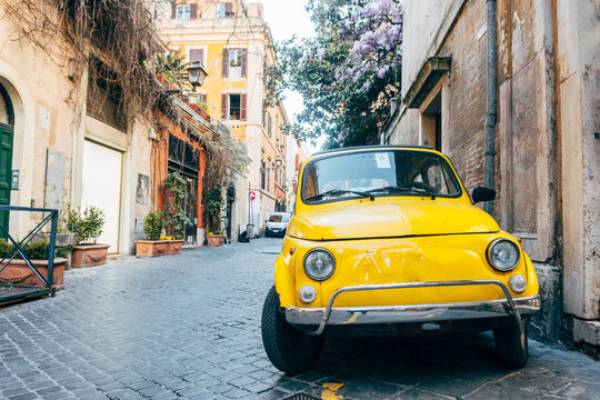 a classic fiat 500 vehicle is parked in roman street