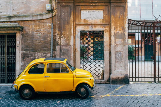 a classic fiat 500 vehicle is parked in roman street
