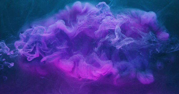 Underwater color explosion. Ink drop. Transition effect. Neon pink purple paint blast on blue mist cloud abstract background shot on Red Cinema camera 6k.