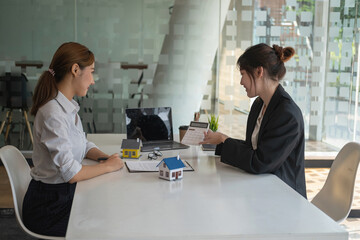 Buying houses and land, guarantees, contract and agreement, An employee of a real estate company hands over the house and keys after the contract for the sale of land and buildings is complete.