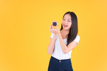 Photo cute pretty asian woman smile showing easy to keep money in piggy bank, Business and money and financial concepts yellow background.