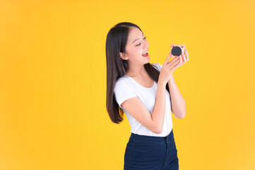 Photo cute pretty asian woman smile showing easy to keep money in piggy bank, Business and money and financial concepts yellow background.