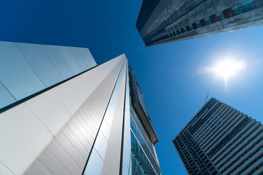 Modern glass buildings in the city on a sunny clear day with a blue sky, photo from bottom to top