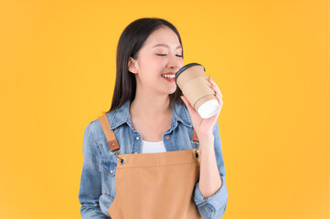 pretty asian female smile coffee freelancer open coffee shop show present and poing to coffee paper cup small business and startup concept yellow background.