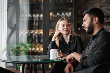 businessman and businesswoman talking sitting at a table in a cafe.