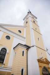 Fototapeta na wymiar Jesenik, Moravia, Czech Republic, 15 April 2022: Church of the Assumption of the Virgin Mary with bell tower at spa city at spring sunny day, Easter time