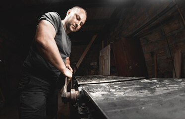 A man works with a large wrench in his home workshop. Making metal products with your own hands