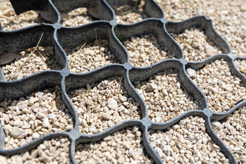 Geogrid used at base of new pedestrian road, road construction, reinforcement covered with fine...