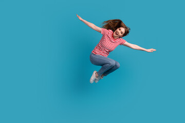 Fototapeta na wymiar Full length profile side photo of young cheerful woman have fun jump arms wings isolated over blue color background