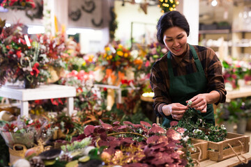 Asian woman selling new year decors at flower shop. Christmas decoration shopping