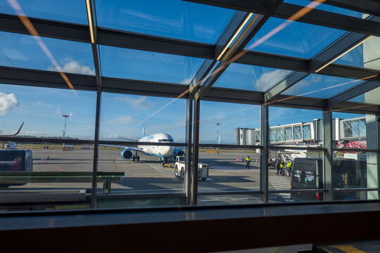 Aircraft behind airport window in daytime
