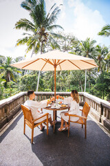 Young Couple Having Breakfast On The Terrace With The Jungle View In Bali, Indonesia