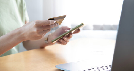 Close-up Of A Woman Holding Credit Card In Hand Doing Online Shopping Using Smart Phone