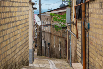 street in the historical center of Derbent on a mountain slope overlooking the Caspian Sea behind the rooftops
