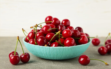 Obraz na płótnie Canvas Fresh sweet cherries bowl on grey background, top view