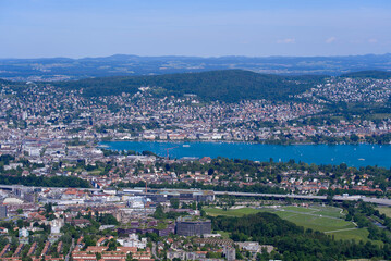Fototapeta na wymiar Aerial view of City of Zürich and Lake Zürich seen from local mountain Uetliberg on a sunny spring day. Photo taken May 18th, 2022, Zurich, Switzerland.
