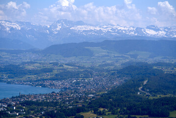 Naklejka premium Aerial view of Lake Zürich and Canton Zürich with the Swiss Alps in the background seen from local mountain Uetliberg on a sunny spring day. Photo taken May 18th, 2022, Zurich, Switzerland.