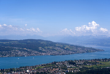 Fototapeta na wymiar Aerial view of Lake Zürich and Canton Zürich with the Swiss Alps in the background seen from local mountain Uetliberg on a sunny spring day. Photo taken May 18th, 2022, Zurich, Switzerland.