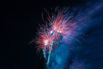 Bright and beautiful festive fireworks in red and white, with a haze of blue