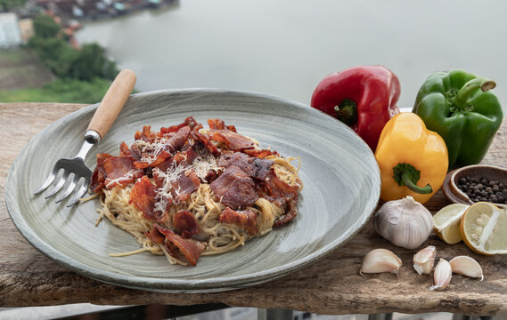 Truffle carbonara spaghetti with fried bacon and grated cheese in ceramic plate. Italian cuisine, Selective Focus.
