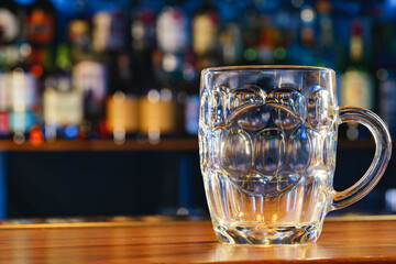 Empty beer glass on a wooden bar counter