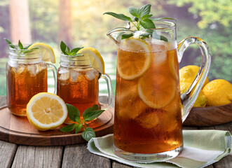 Pitcher of cold ice tea with rural summer background - 509579301