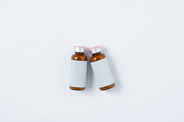 The vaccine is in a brown glass jar with  white label. White background.