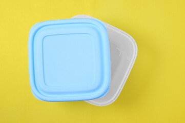 Plastic container with  lid for food. Yellow background.