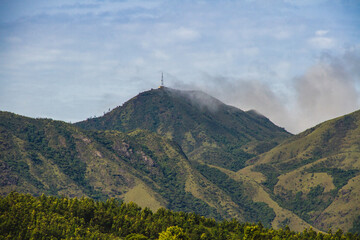 Fog visiting the green mountain ranges in the morning at a resort in ooty. Cloud covered mountains. 