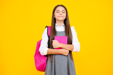 Back to school. Teenager schoolgirl hold book and copybook ready to learn. School children on isolated yellow studio background.