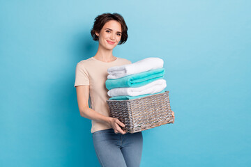 Photo of young stunning lady working at cleaning service hold pile of washed clothes isolated on...