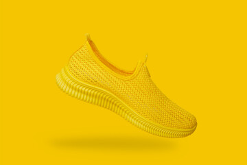 Yellow summer women's sneaker without laces on a yellow background. Close-up.