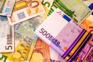 A pack of European currency lies on the background of the Euro
