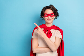 Photo of dreamy sweet woman wear red cape smiling pointing finger empty space isolated blue color background