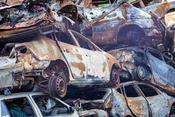 Russian invasion of Ukraine in 2022, destroyed and burned cars. Cars were beaten with shrapnel and...