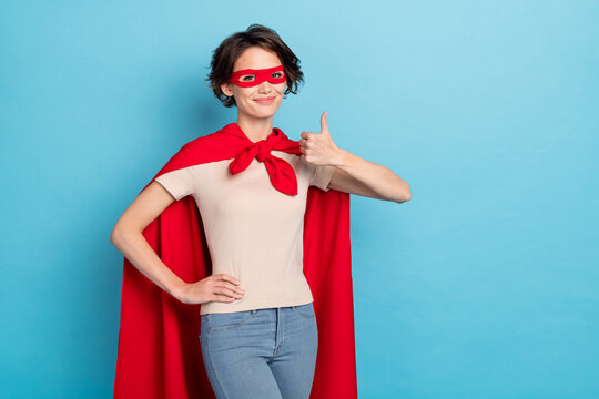 Photo of strong cool woman wear red cape showing thumb up empty space isolated blue color background