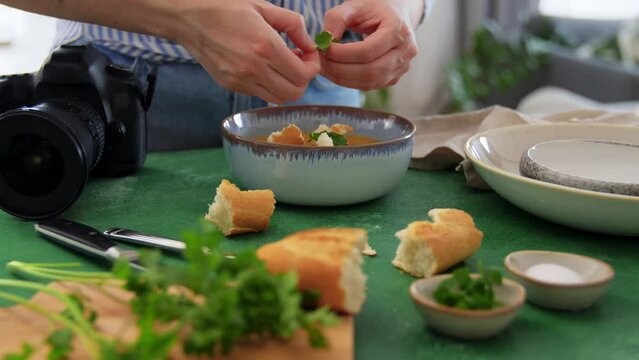 blogging, photographing and people concept - happy smiling female food photographer with camera arranging composition in kitchen at home