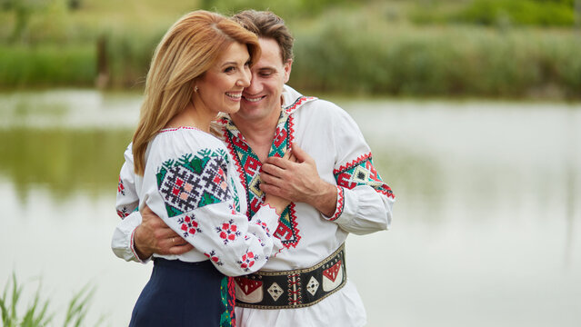 Happy couple wife and husband together embracing posing in Romanian national clothes.
