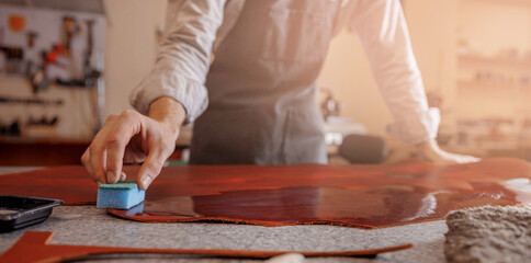 Man master shoemaker tailor covers skin with protective layer for further work