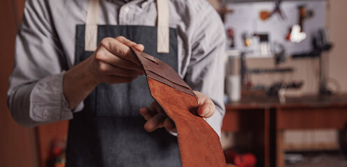 Craft man tailor checks handmade brown leather product, handicraft production