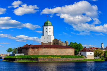 Fototapeta na wymiar Medieval fortress in Vyborg. Castle on the water against the blue sky with clouds