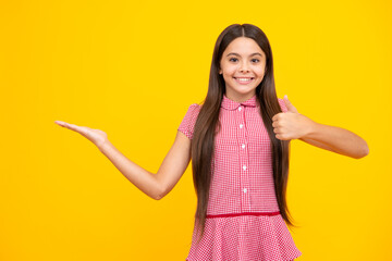 Teenager child pointing to the side with a finger to present a product or idea. Teen girl in casual outfit pointing empty space.
