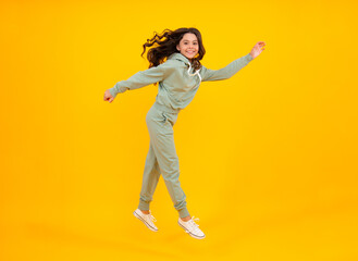 Fototapeta na wymiar Full length of attractive cheerful girl in sport wear isolated over yellow background. Sportwear for teenager child.