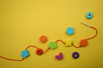 wooden beads for child development on a yellow background