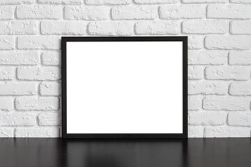 Blank picture frame against brick wall with copy space