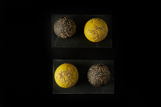 sesame buns yellow and black on black slate boards. black background images. top view