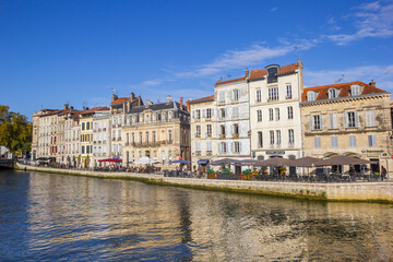 Historic houses reflected in the Nive river in Bayonne, France