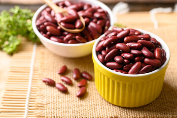 Red kidney beans in yellow bowl on wooden table, Food ingredients