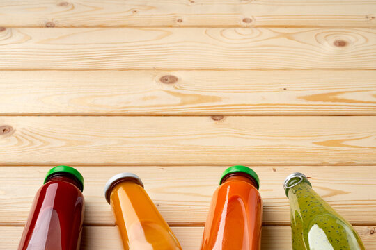 Juice bottles on wooden background flat lay